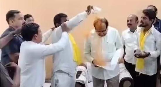 Indian man sprays Minister with Turmeric